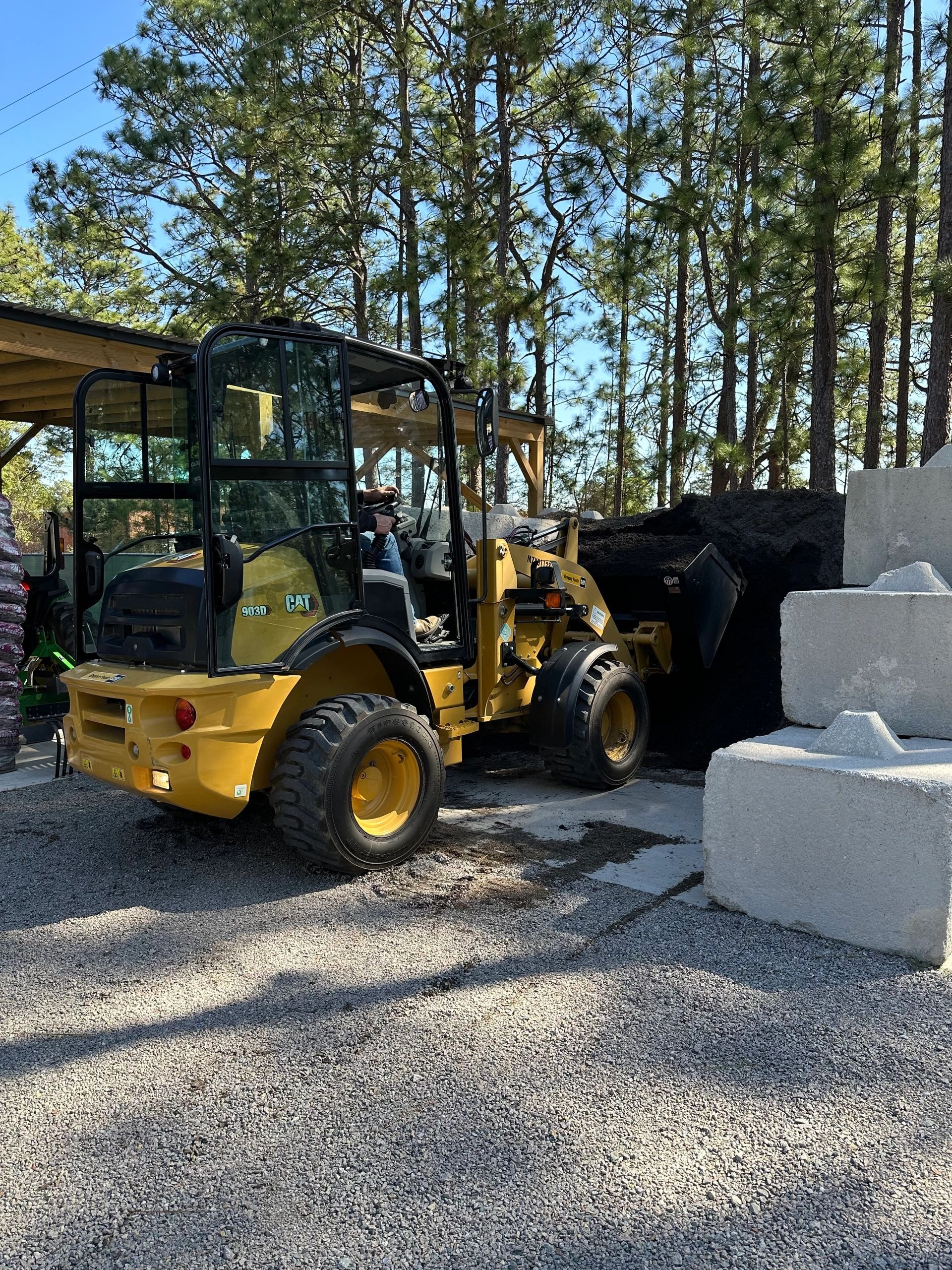 CAT loader bucket filling with bulk topsoil